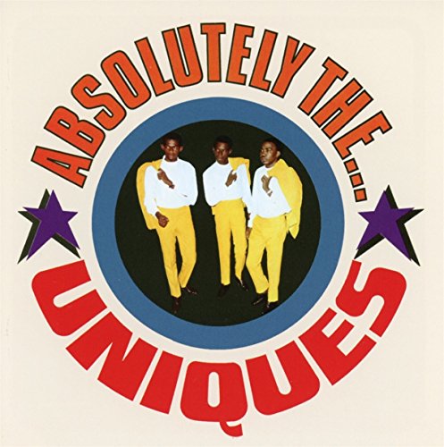 Album cover featuring three men in yellow suits, surrounded by text and purple stars.