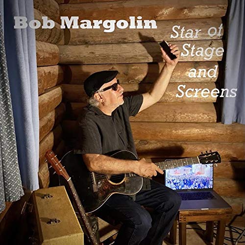 "Album cover featuring a man sitting with a guitar and holding a phone."