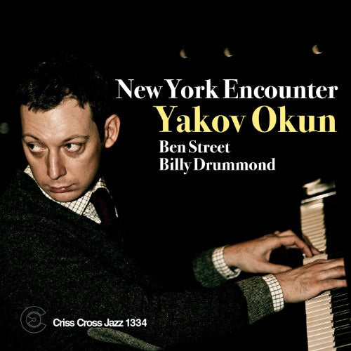 "CD cover with a man playing piano, black background, and white text."