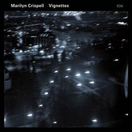 "Album cover with a blurry nighttime cityscape and white text on a black background."
