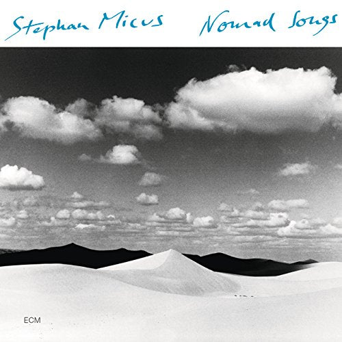 "Album cover featuring a black and white desert landscape with cloudy sky."