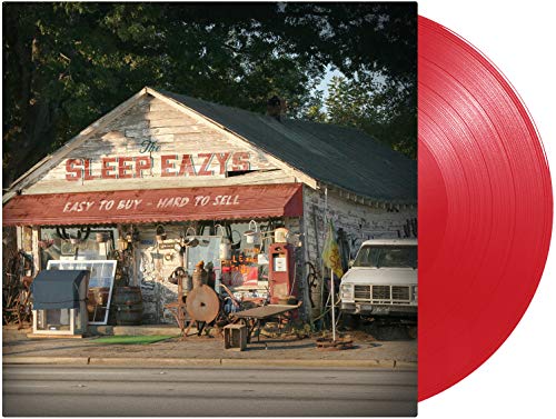 "Red vinyl record with album cover featuring a rustic storefront and vintage items."