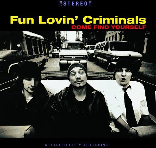 "Album cover with three men in a car, city street in the background."