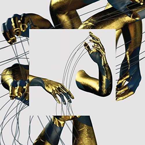 The image shows a gold-painted hand manipulating strings against a grey background. For the alt text: "Gold-painted hands manipulating strings on a grey background."
