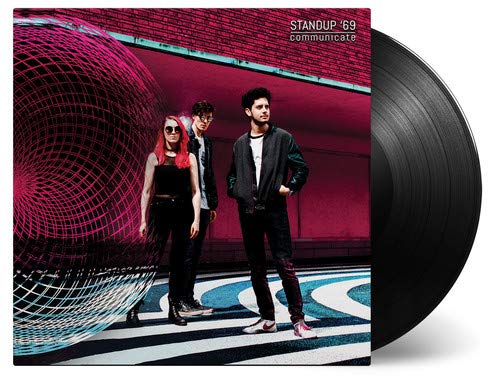 "Black vinyl record with album cover featuring three people standing on a patterned floor."