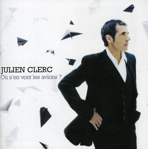 Man in black suit surrounded by paper airplanes on a white background, album cover.