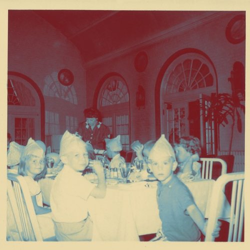 Album cover featuring children at a formal dining table with a server.