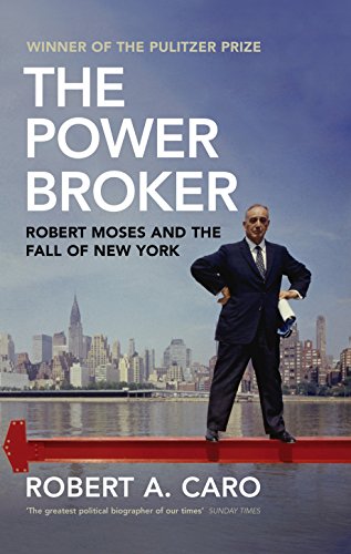 Book cover with a man standing on a red bulldozer blade, New York City skyline.