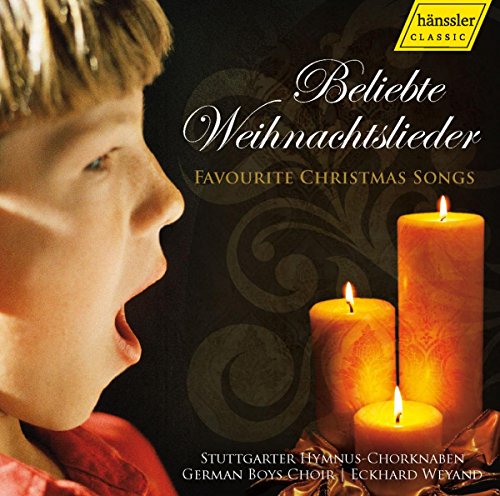 "CD cover featuring a boy singing with two lit candles on a dark background."