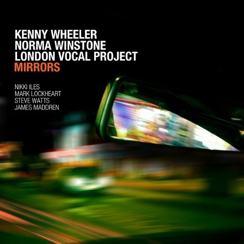 "Album cover with blurry green and orange lights, black background, and white and orange text."