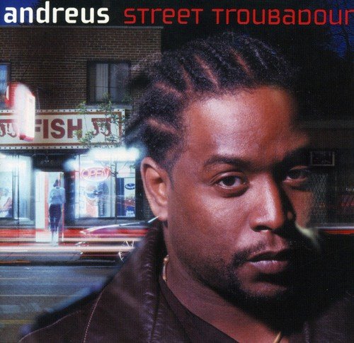 "Album cover featuring a man with braids in front of a city street at night."