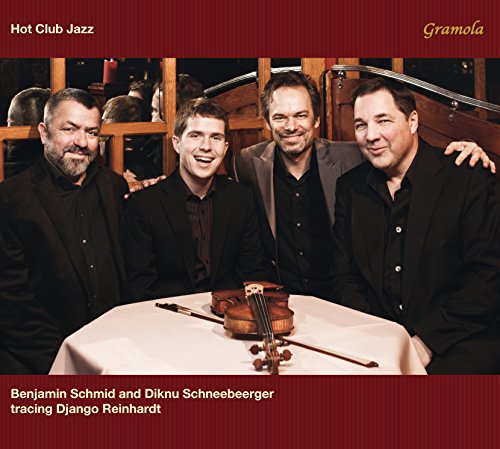 "CD cover with four men and a violin on a table."