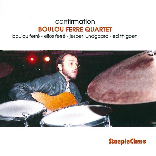 "CD cover featuring a man playing guitar and drums on stage with cymbals."
