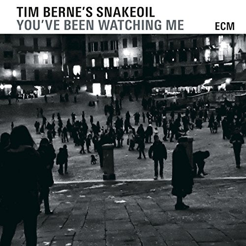 "Album cover with black and white cityscape image and text 'Tim Berne's Snakeoil You've Been Watching Me'."