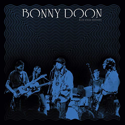 "Vinyl album cover with blue-toned band performing on stage, black background."
