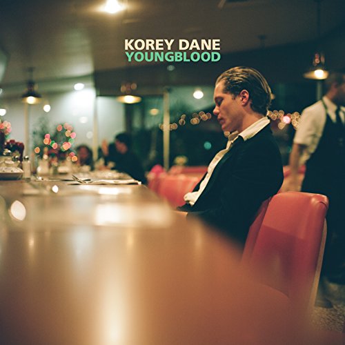 "Album cover featuring a man sitting alone at a diner counter, looking down."