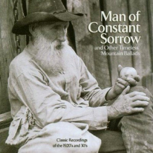 "Black and white CD cover featuring an elderly man holding a porcelain doll."