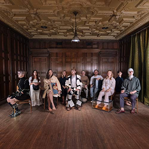 Group of ten people seated in a formal room with ornate ceiling.