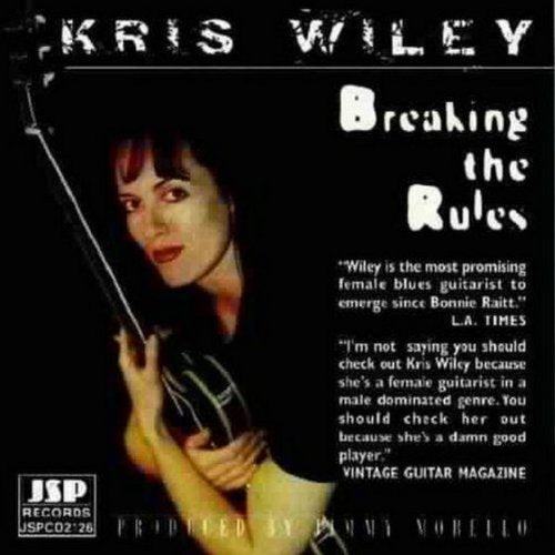 "Kris Wiley album cover featuring a woman holding a guitar against a black background."