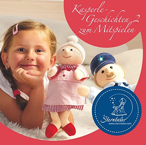 A young girl lies on a rug with two smiling dolls beside her.