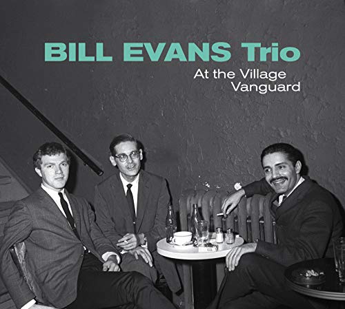 "Black and white photo of three suited men sitting at a small table."