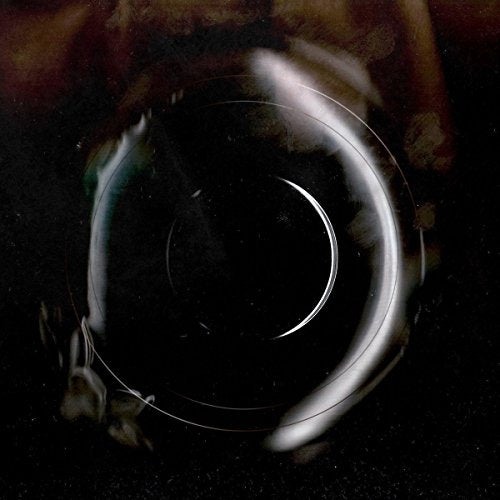 A CD is shown against a dark background, reflecting light and surrounding objects.