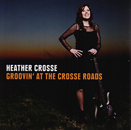 Album cover with a woman in black holding a guitar, outdoors at dusk.