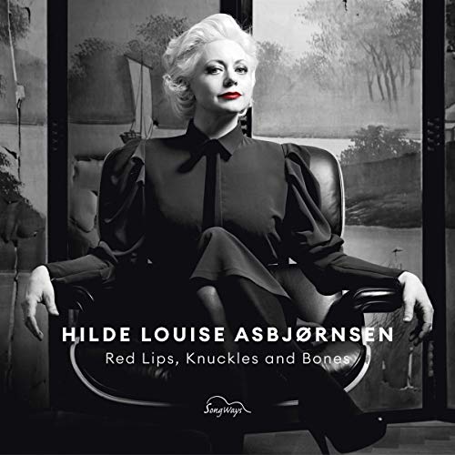 Woman in black dress sits in chair, album title and artist name displayed prominently.