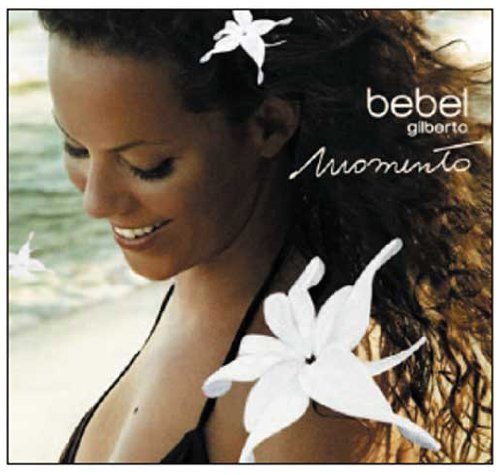 Bebel Gilberto's album cover featuring a smiling woman surrounded by white flowers on a beach.