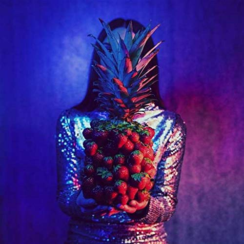 A woman in a shiny dress holding strawberries with a pineapple for a head.