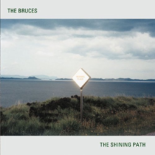 Album cover with a sign reading "The Shining Path" by the sea.
