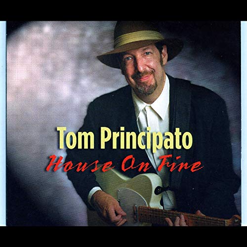 "Album cover featuring Tom Principato holding a guitar, wearing a hat and suit."