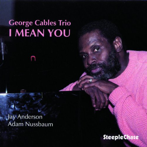 "CD cover featuring a man in a pink sweater resting on a piano."