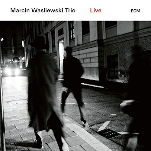 "Album cover with black and white image of people walking on a city street at night."
