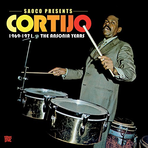 Album cover with man playing drums, against a black background.