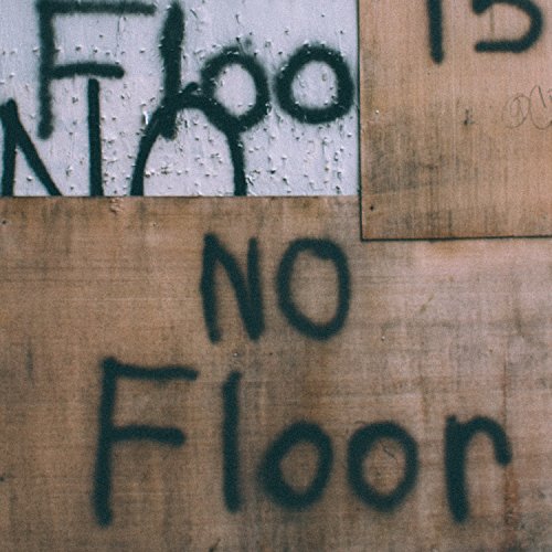 The image shows a close-up of a wall with "NO Floor" spray-painted on it.