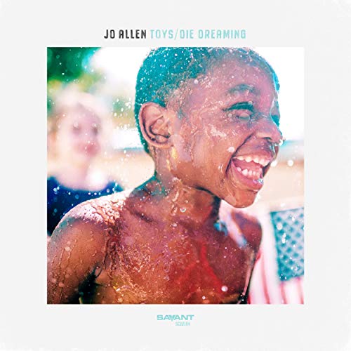 Album cover with a boy smiling, covered in water, and a blurred background.