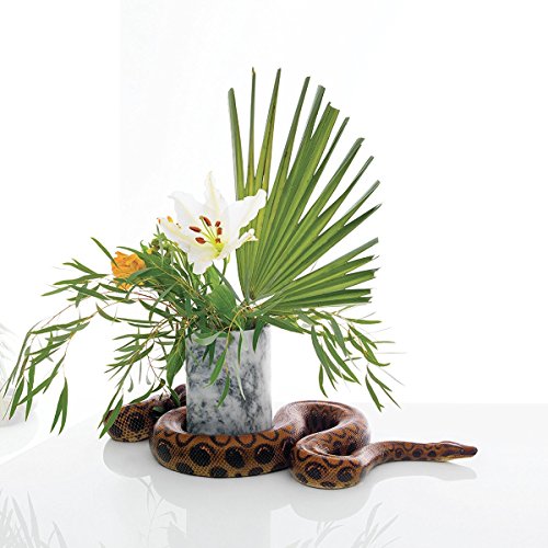A brown snake coiled around a white marble vase with flowers and greenery.