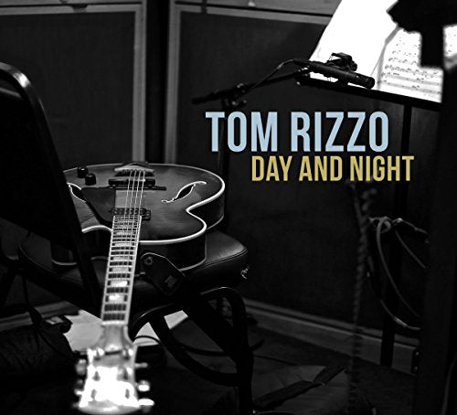 Guitar on chair with music stand beside it, text "Tom Rizzo Day and Night" overlay.