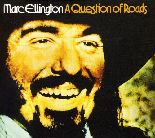 "Album cover with a close-up of a man's face, smiling, against a black background."