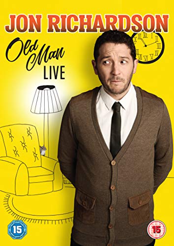 Man in brown cardigan and tie stands against a yellow background with drawn furniture.