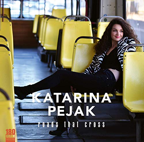 Album cover with a woman sitting on a bus with yellow seats.