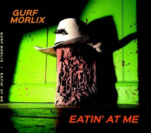 "CD album cover with a crumbling post wearing a white cowboy hat against a green wall."