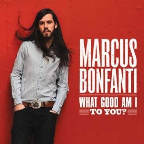 Man with long hair stands against red background with album title text.