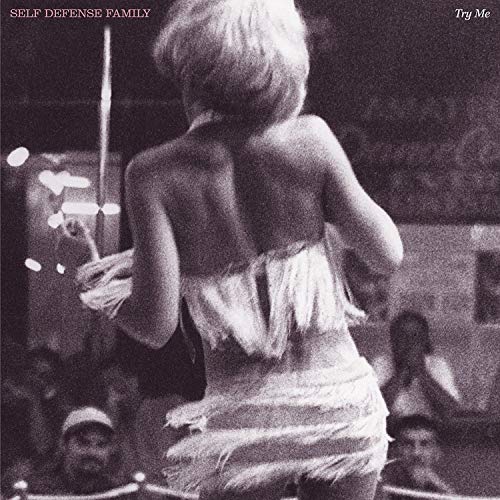 Black and white album cover with a woman holding a whip, facing away.