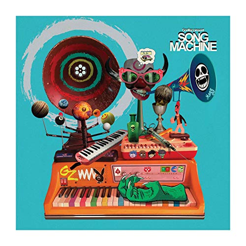 The image shows a vinyl record album cover with a cartoonish, surreal design. Key elements include a large orange keyboard, a vinyl record, and various objects. Alt text: "Vinyl album cover with cartoon keyboard and surreal objects on turquoise background."