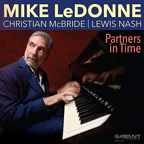 "Album cover featuring a man playing piano, titled 'Partners in Time'."