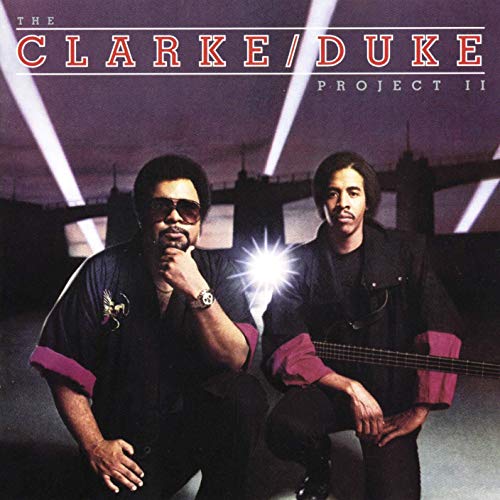"Album cover with two men crouched, one holding a guitar, against a bridge at night."