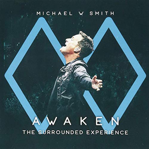 The alt text for the image is: "Album cover with man standing in front of blue diamond shapes."