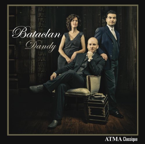 Album cover with three people posing formally, man seated with briefcase nearby, against dark background.
